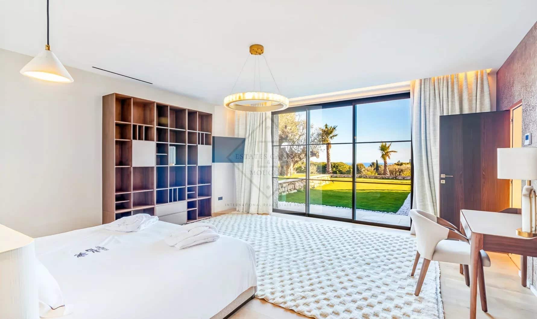 Chambre lumineuse d'une villa contemporaine à Super Cannes avec vue sur le jardin.