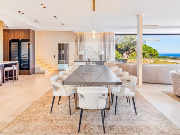 Intérieur d'une villa contemporaine à Super Cannes avec vue sur la mer, salle à manger et espace de vie.