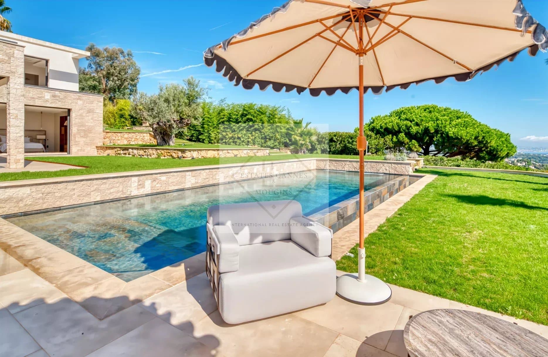 Villa contemporaine avec piscine et parasol, vue sur le jardin à Super Cannes.