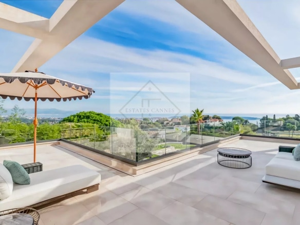Terrasse d'une villa contemporaine à Super Cannes avec vue sur la mer et mobilier extérieur.