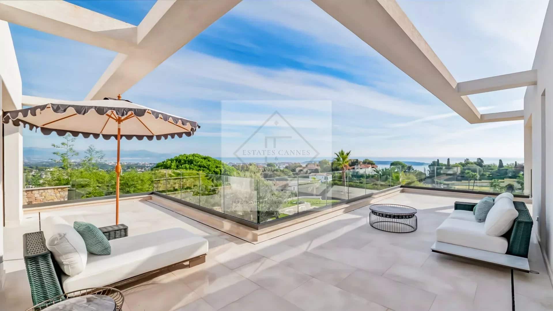 Terrasse d'une villa contemporaine à Super Cannes avec vue sur la mer et mobilier extérieur.