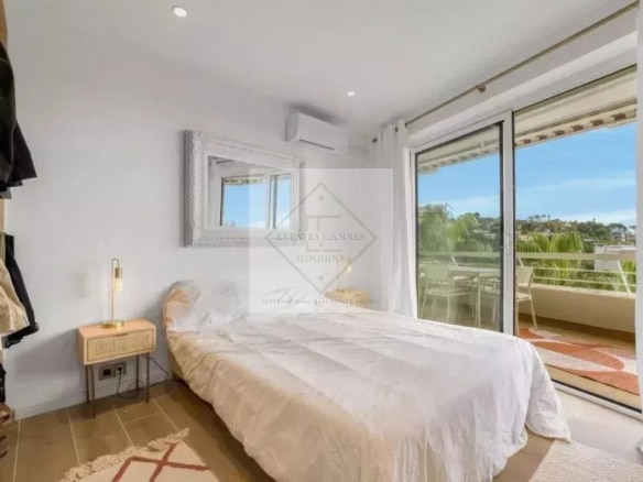 Chambre d'un appartement rénové avec balcon et vue sur la mer à Cannes.