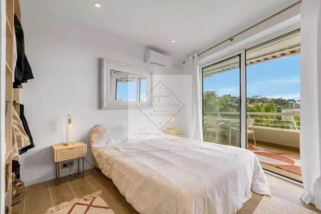 Chambre d'un appartement rénové avec balcon et vue sur la mer à Cannes.