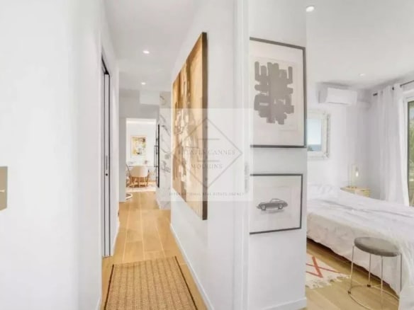 Intérieur d'un appartement rénové avec couloir et chambre, lumineux et moderne.