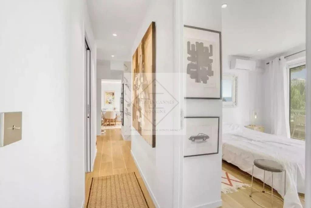 Intérieur d'un appartement rénové avec couloir et chambre, lumineux et moderne.