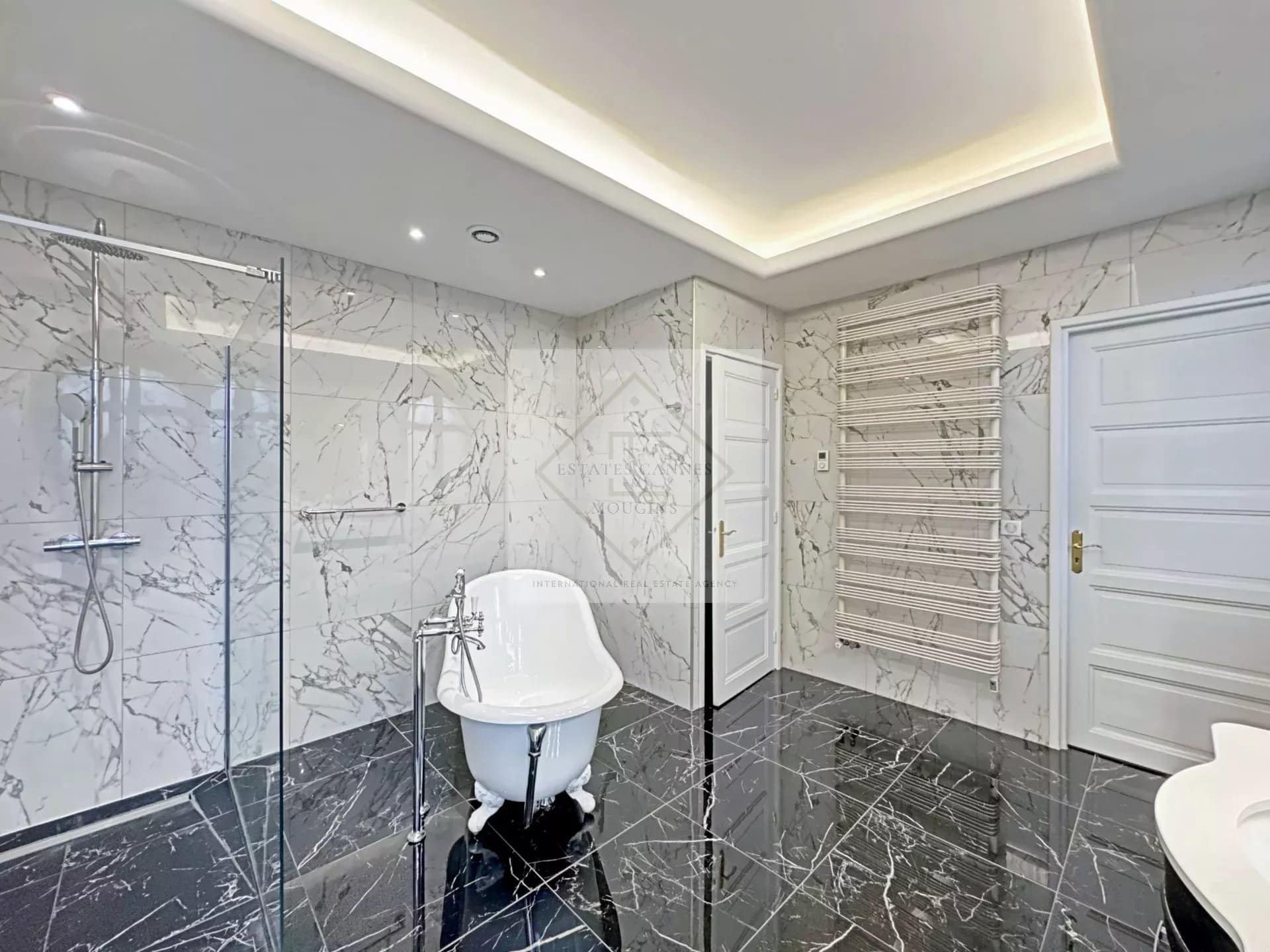 Modern bathroom with marble bath and shower in a luxury villa in Cannes.
