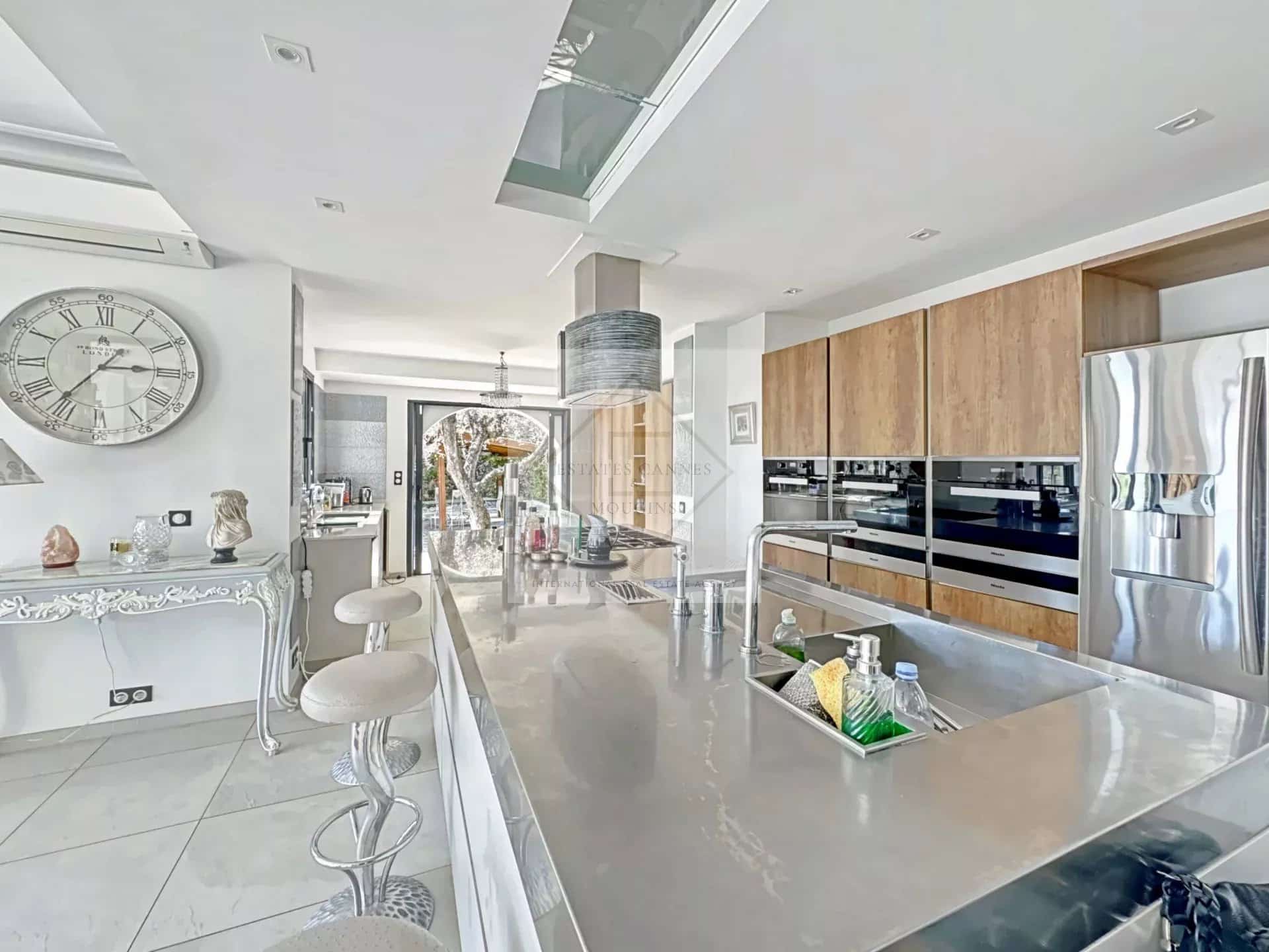 Modern and spacious kitchen in a luxury villa in Cannes, with central island and high-end equipment.