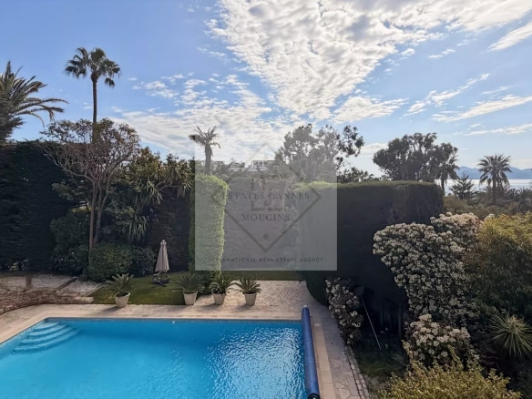 View of a luxury villa with pool and garden in Cannes, California.