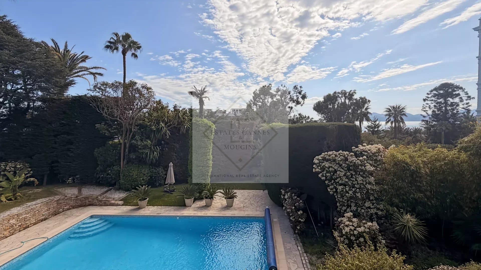 View of a luxury villa with pool and garden in Cannes, California.