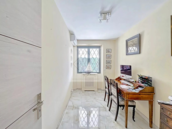 Intérieur d'une villa à Cannes avec un bureau et une fenêtre laissant passer la lumière naturelle.