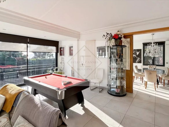 Intérieur d'une villa moderne à Cannes avec billard et salle à manger lumineuse.