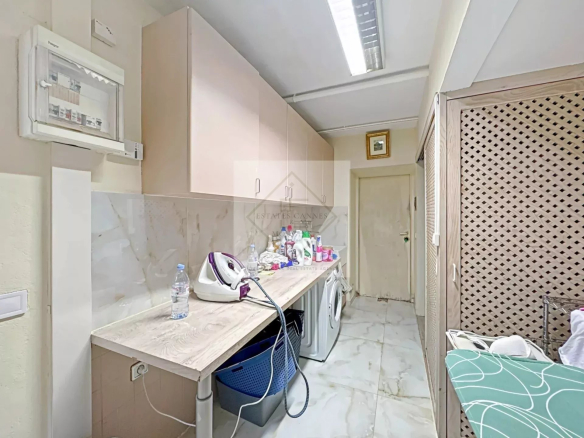 Buanderie d'une villa à vendre à Cannes, avec machines à laver et divers produits de nettoyage.