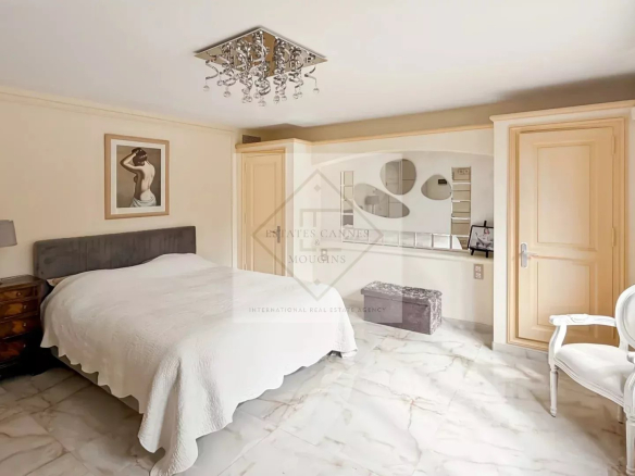 Chambre d'une villa à Cannes avec lit, meubles en bois et décoration moderne.
