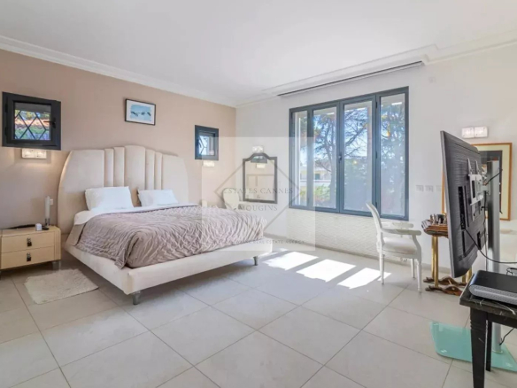 Chambre lumineuse dans une villa moderne à Cannes, avec un lit king-size et une vue sur le jardin.