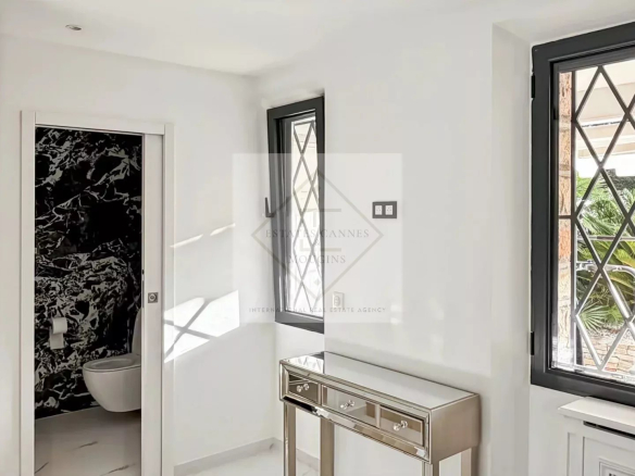 Intérieur lumineux d'une villa moderne à Cannes, avec des fenêtres et un mobilier élégant.