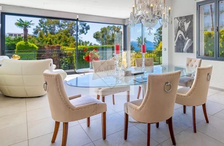 Salle à manger d’une villa à Cannes Intérieur d'une villa moderne à Cannes avec salle à manger élégante et vue sur la nature.