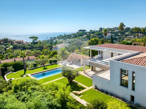 Aerial view of a contemporary villa with swimming pool and garden, overlooking the sea in Cannes.