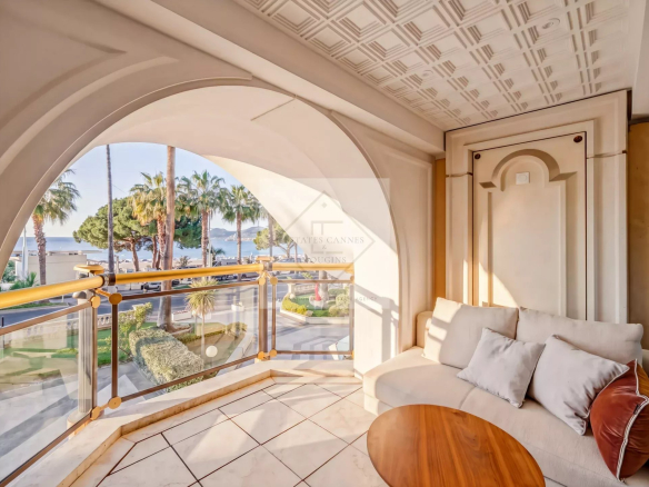 Balcony of an apartment with a view of the sea and palm trees in Cannes.