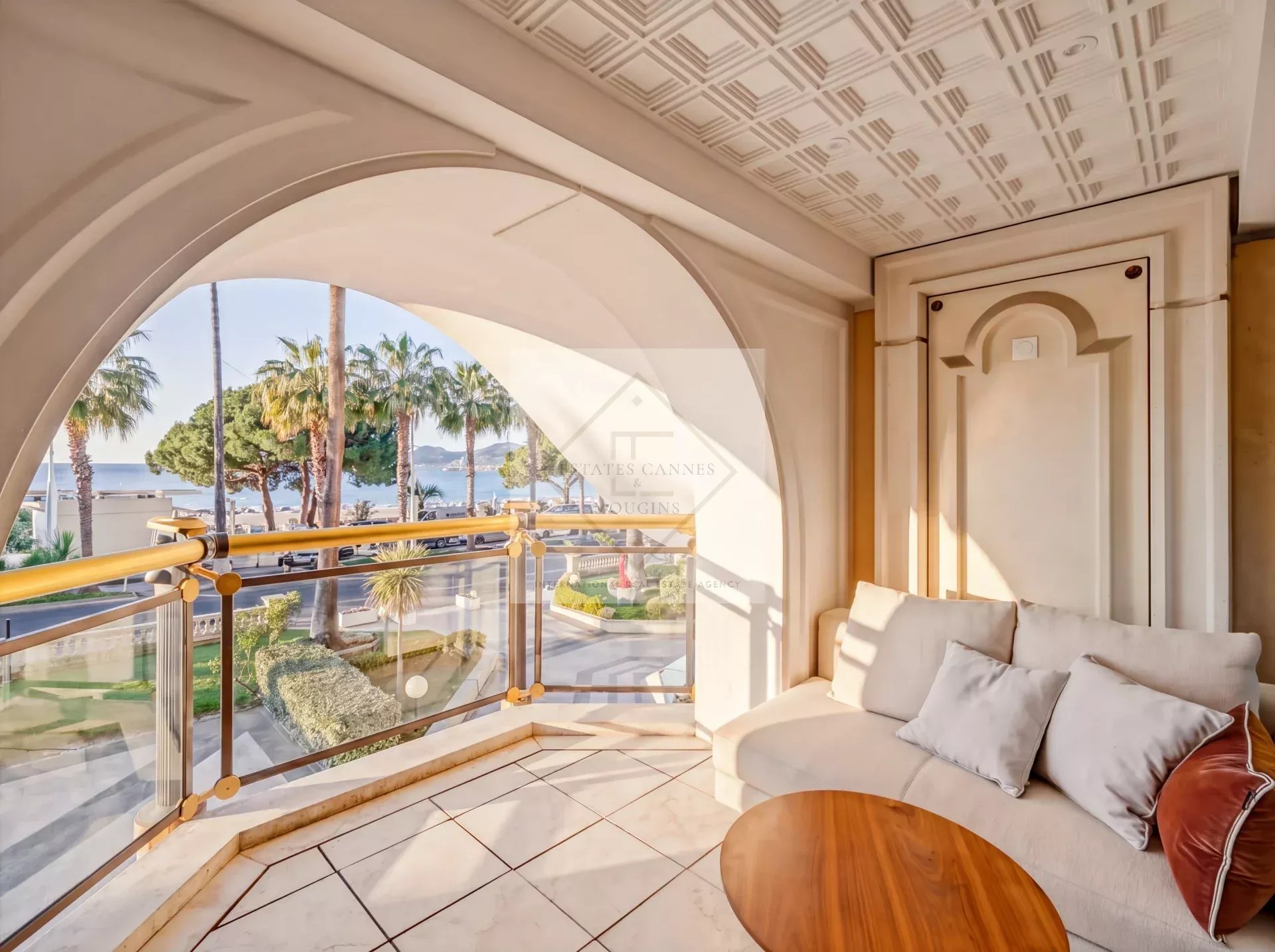 Balcony of an apartment with a view of the sea and palm trees in Cannes.
