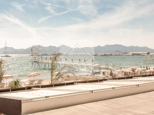 Panoramic sea view from the Croisette in Cannes, with beaches and mountains in the background.