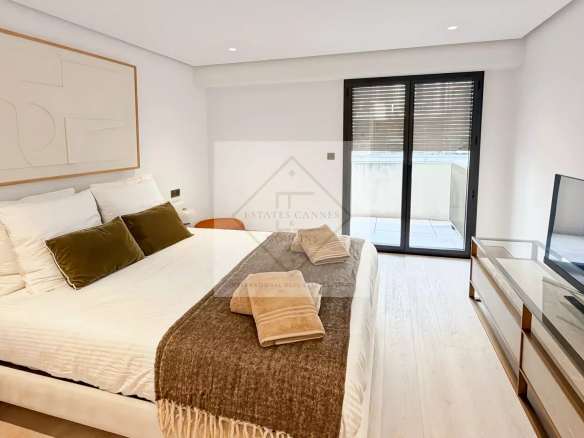 Room in a modern apartment with double bed, television and access to a balcony in Cannes.