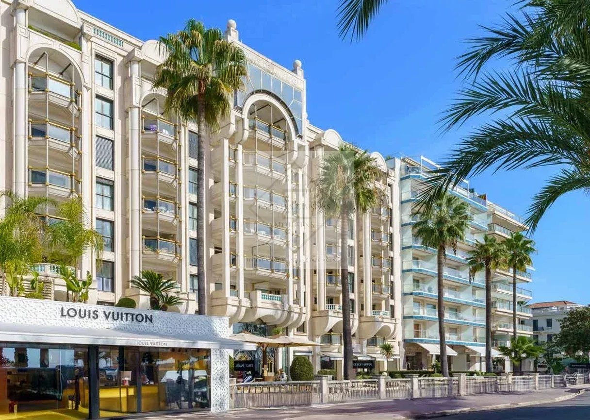 Historic building on the Croisette in Cannes with sea views and shops below.