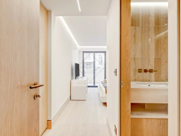 Interior of a modern apartment with wooden door and visible bathroom in Cannes.