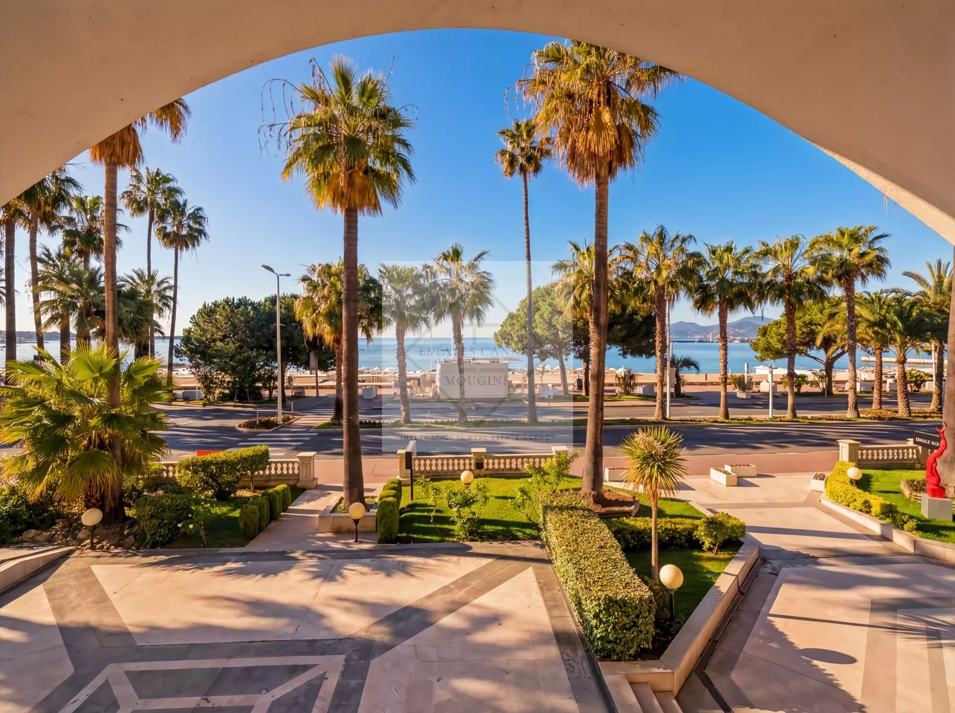 View from an apartment on the Croisette in Cannes, with palm trees and the sea in the background.