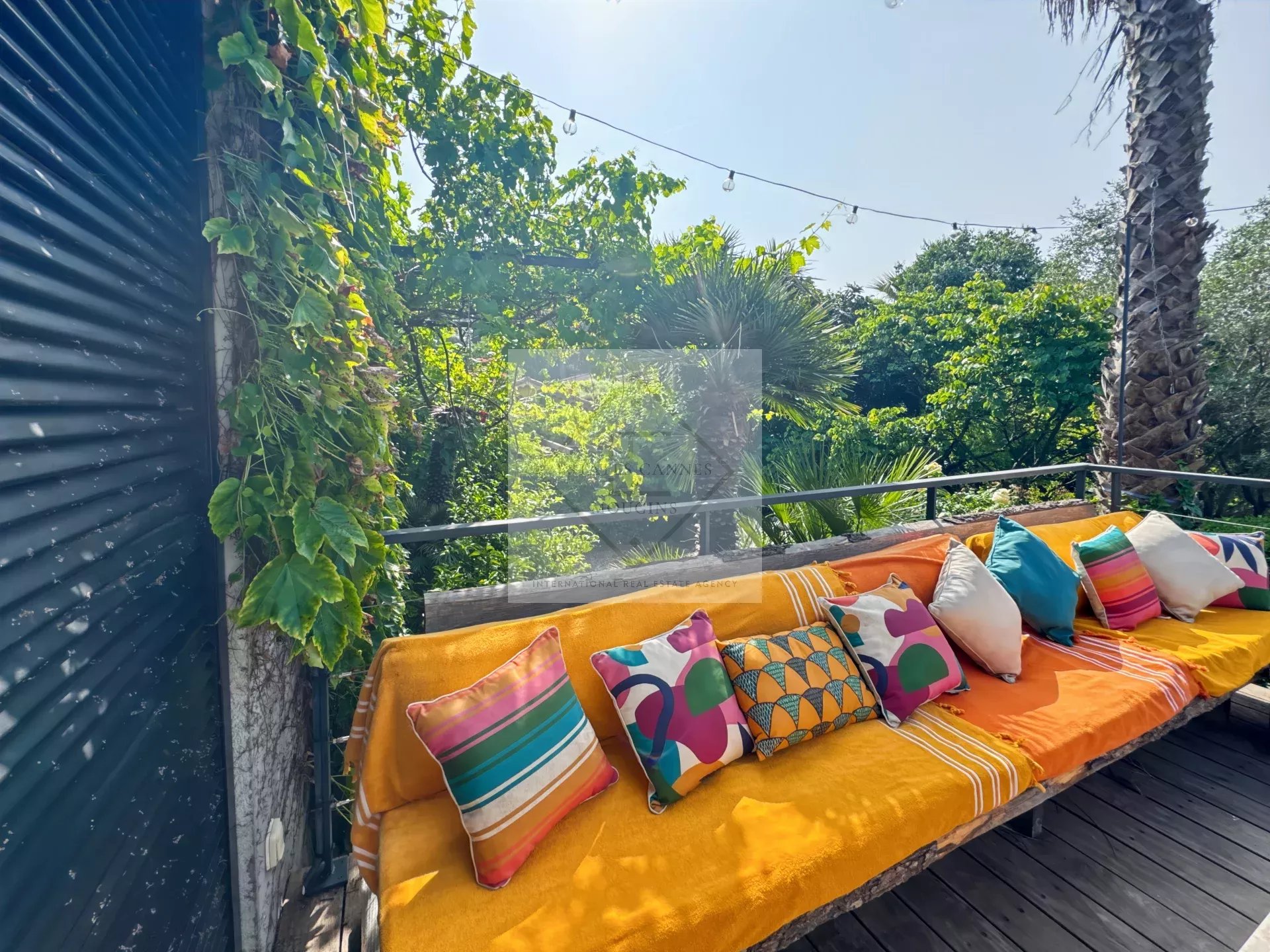Terrace with colorful cushions Sunny terrace with colorful cushions surrounded by greenery.