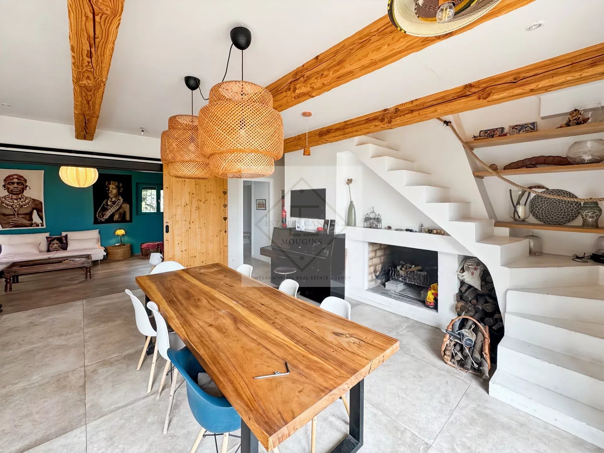Elegant interior of a house in Mougins Interior of a modern house with a large wooden table, white chairs and a decorated living room.