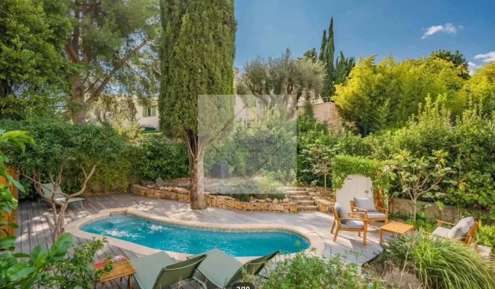 Maison de ville avec piscine à Cannes Jardin avec piscine et chaises longues dans une maison de ville à Cannes.