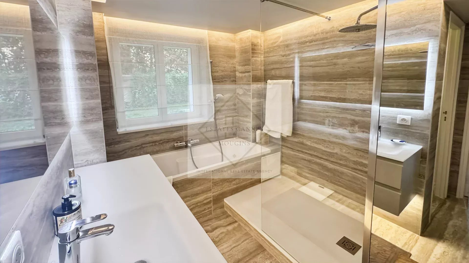 Salle de bain contemporaine Salle de bain moderne avec douche et baignoire, murs en marbre, lumière naturelle