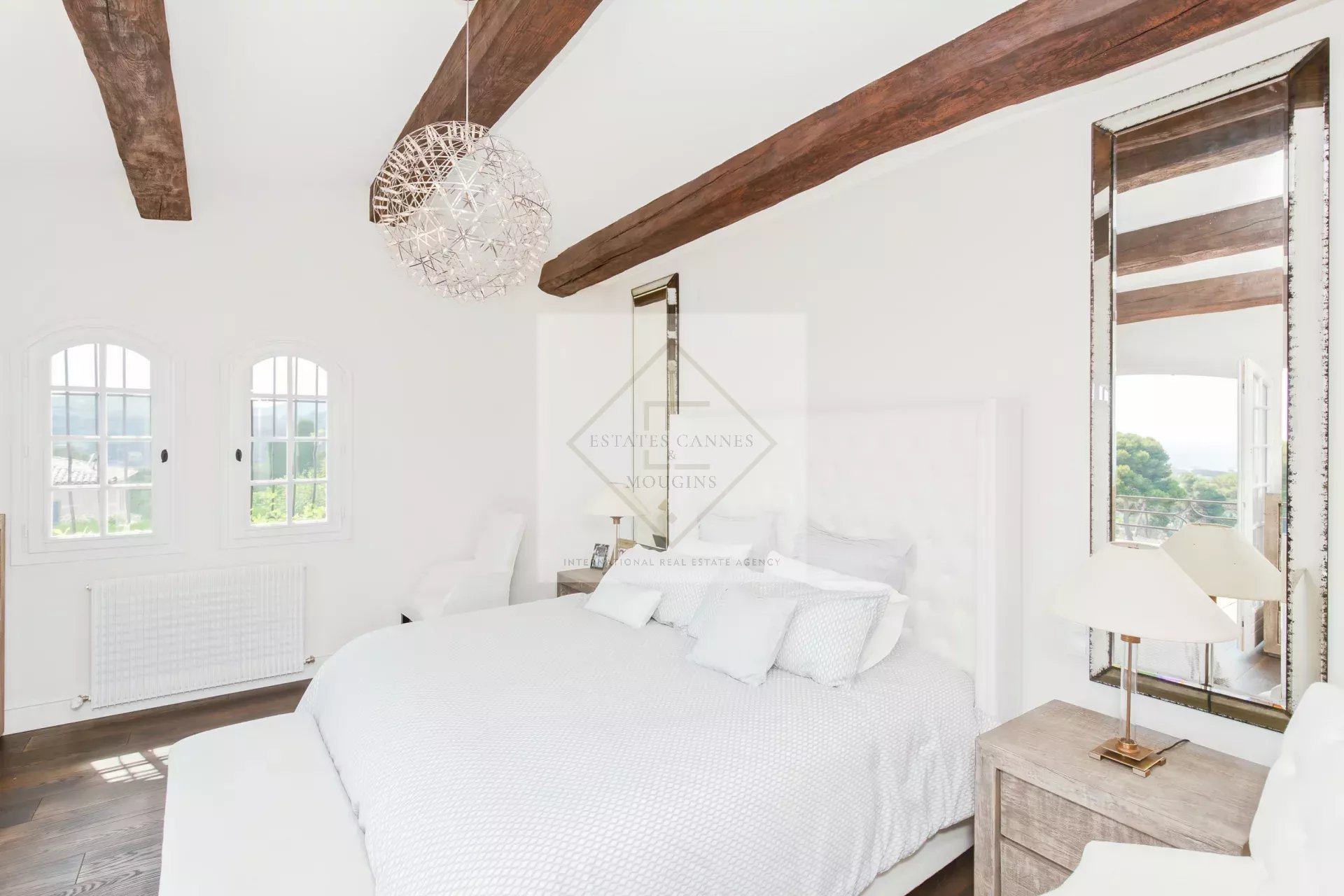Chambre rénovée en pierre à Antibes Chambre élégante avec lit king-size et poutres apparentes dans une maison en pierre à Antibes.