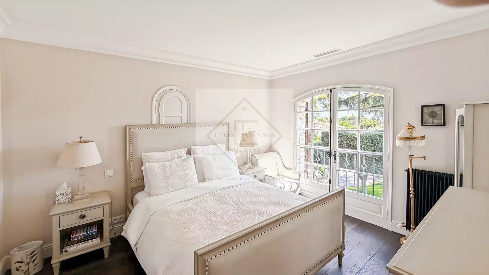 Chambre élégante à Antibes Chambre d'une maison en pierre rénovée à Antibes, avec lit élégant et fenêtres offrant une vue sur l'extérieur.