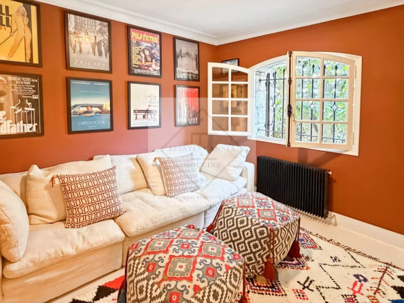 Intérieur d'une maison en pierre rénovée avec un salon confortable et des œuvres d'art aux murs.