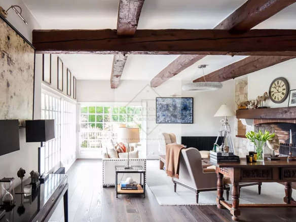 Intérieur d'une maison en pierre rénovée avec des poutres apparentes et un mobilier élégant à Antibes.