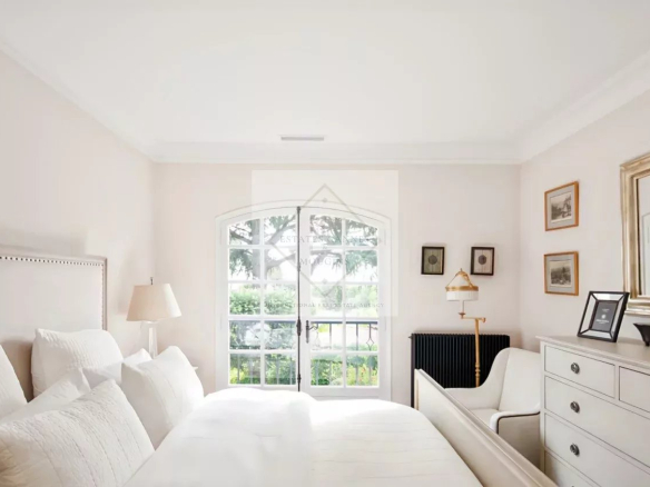 Chambre lumineuse d'une maison en pierre rénovée à Antibes, avec vue sur le jardin.