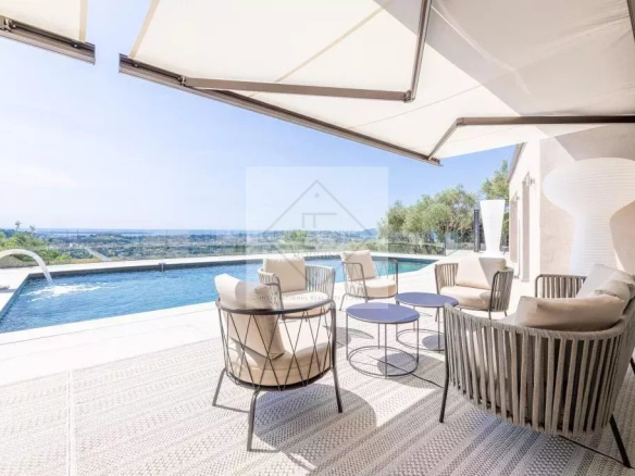 Terrace of a modern villa with sea view in Mougins, swimming pool and outdoor furniture.