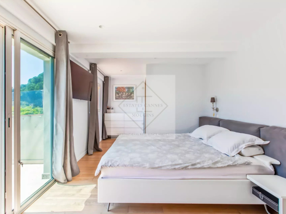 Chambre lumineuse avec lit double et accès à un balcon, villa à Mougins.