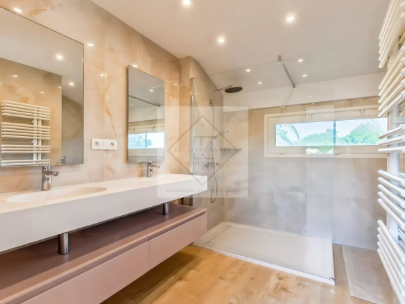 Salle de bain moderne avec douche et double vasque dans une villa à Mougins.