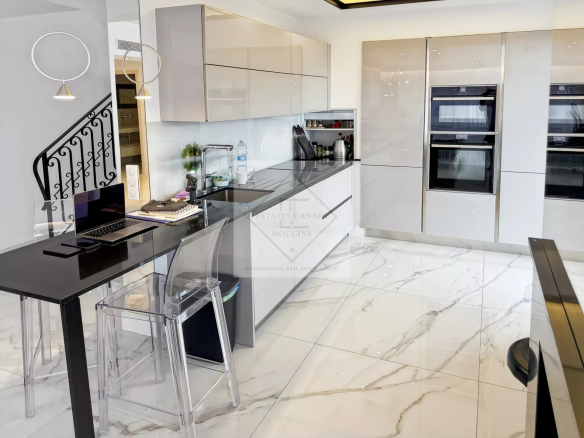 Cuisine moderne d'une villa provençale avec mobilier élégant et plan de travail en marbre.