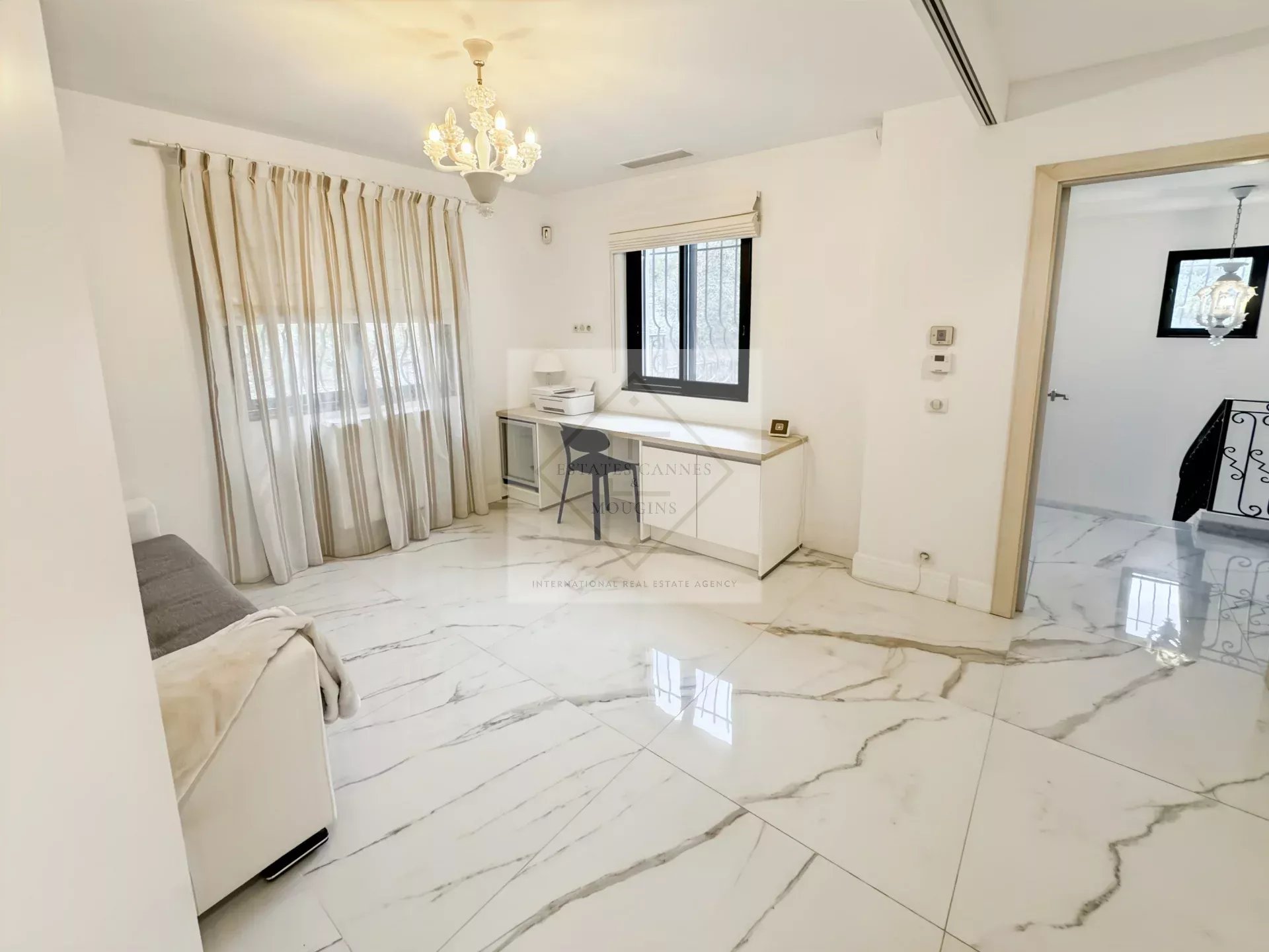 Intérieur d'une villa provençale avec un sol en marbre et un espace de travail lumineux.