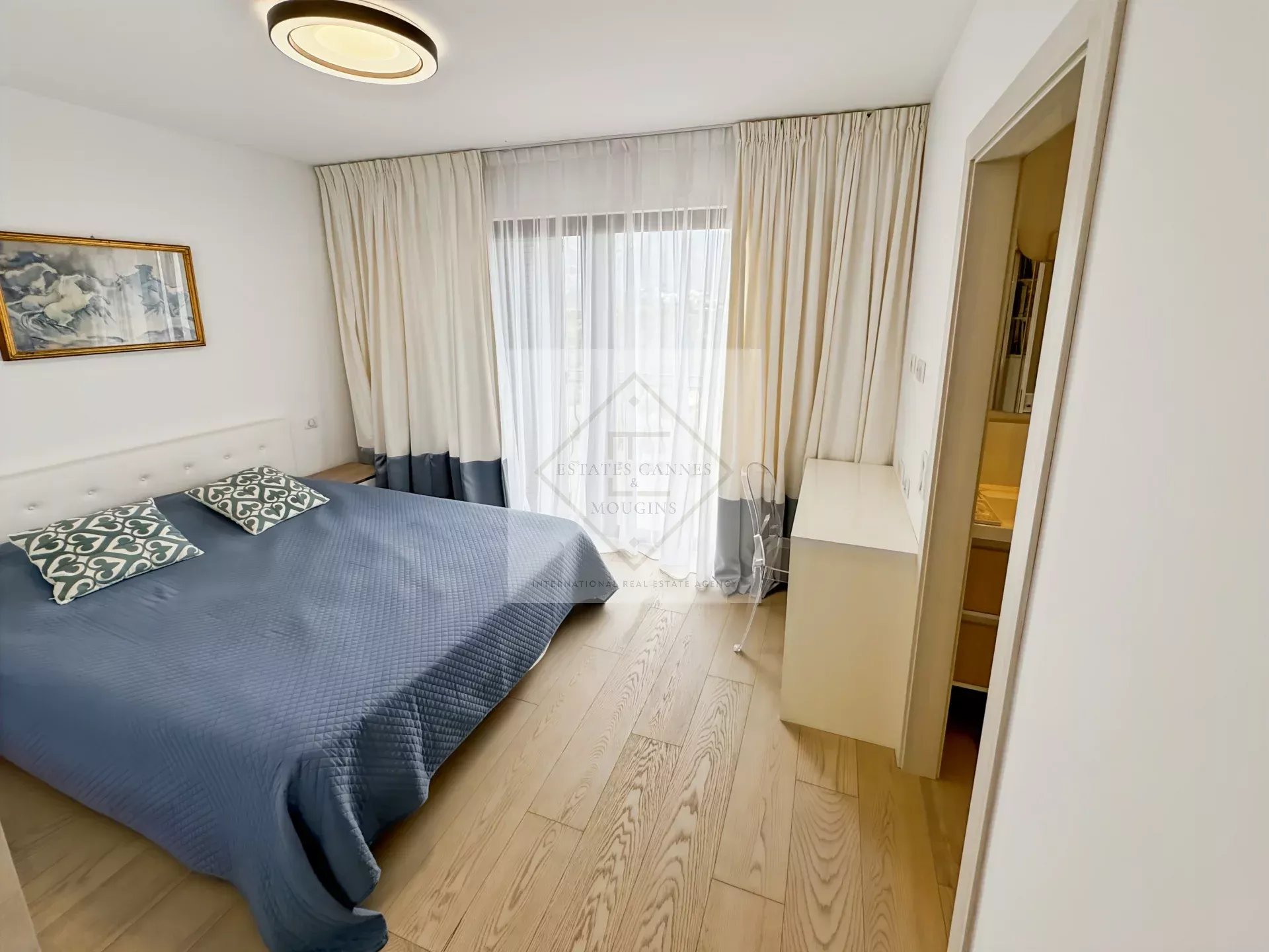 Chambre d'une villa provençale avec lit double et accès à une salle d'eau.
