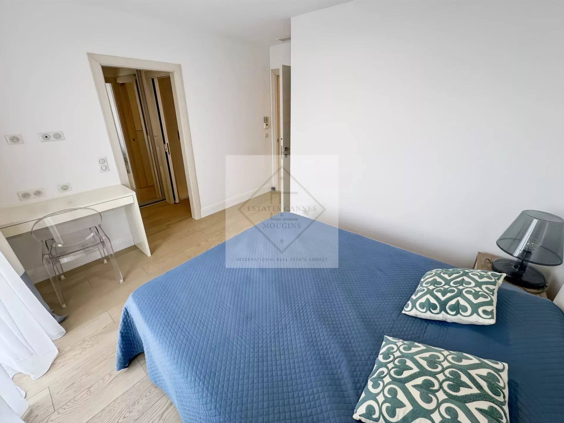 Chambre d'une villa provençale avec lit, bureau et décoration moderne.