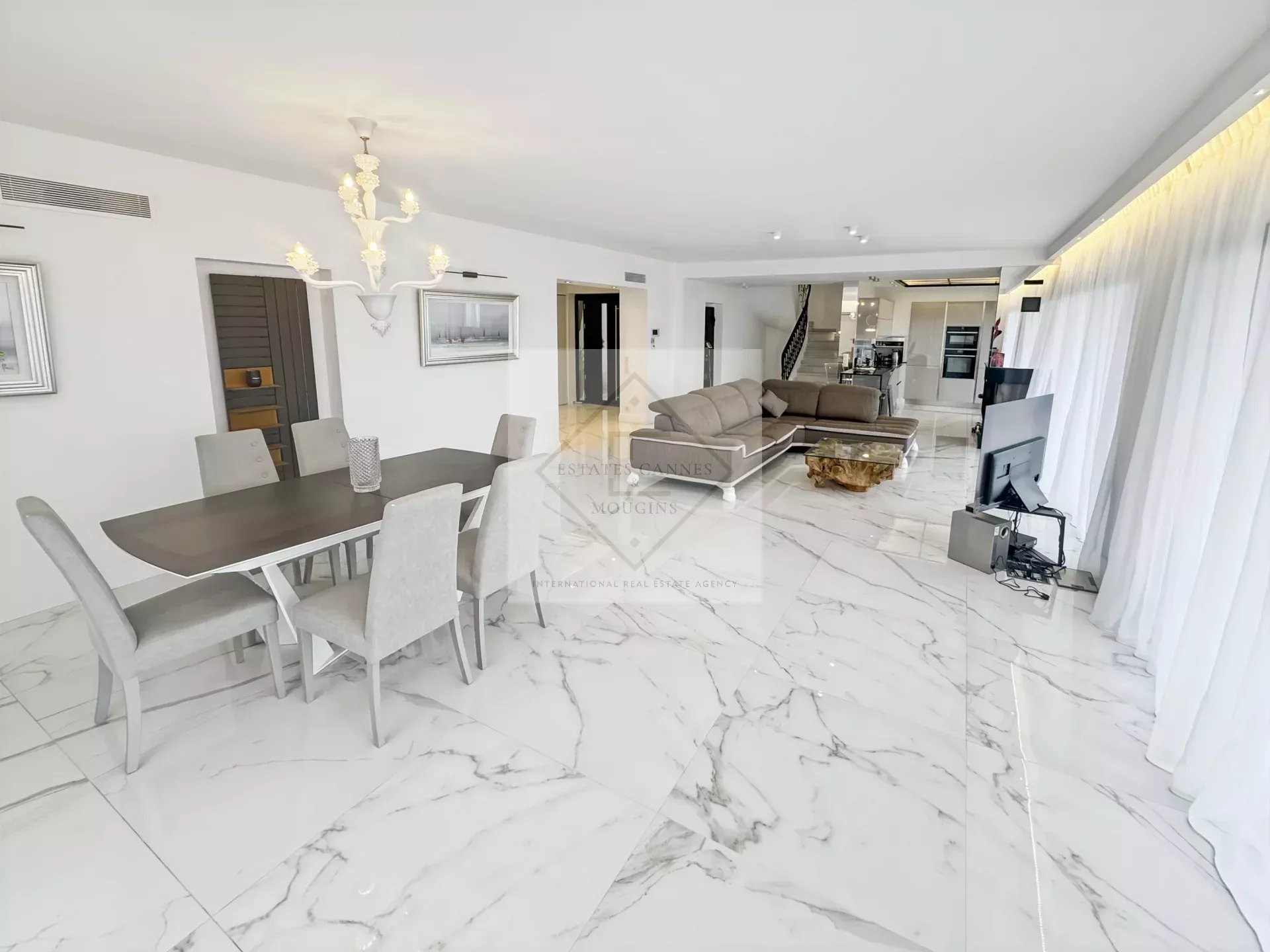 Intérieur d'une villa provençale moderne avec salon et salle à manger spacieuse.