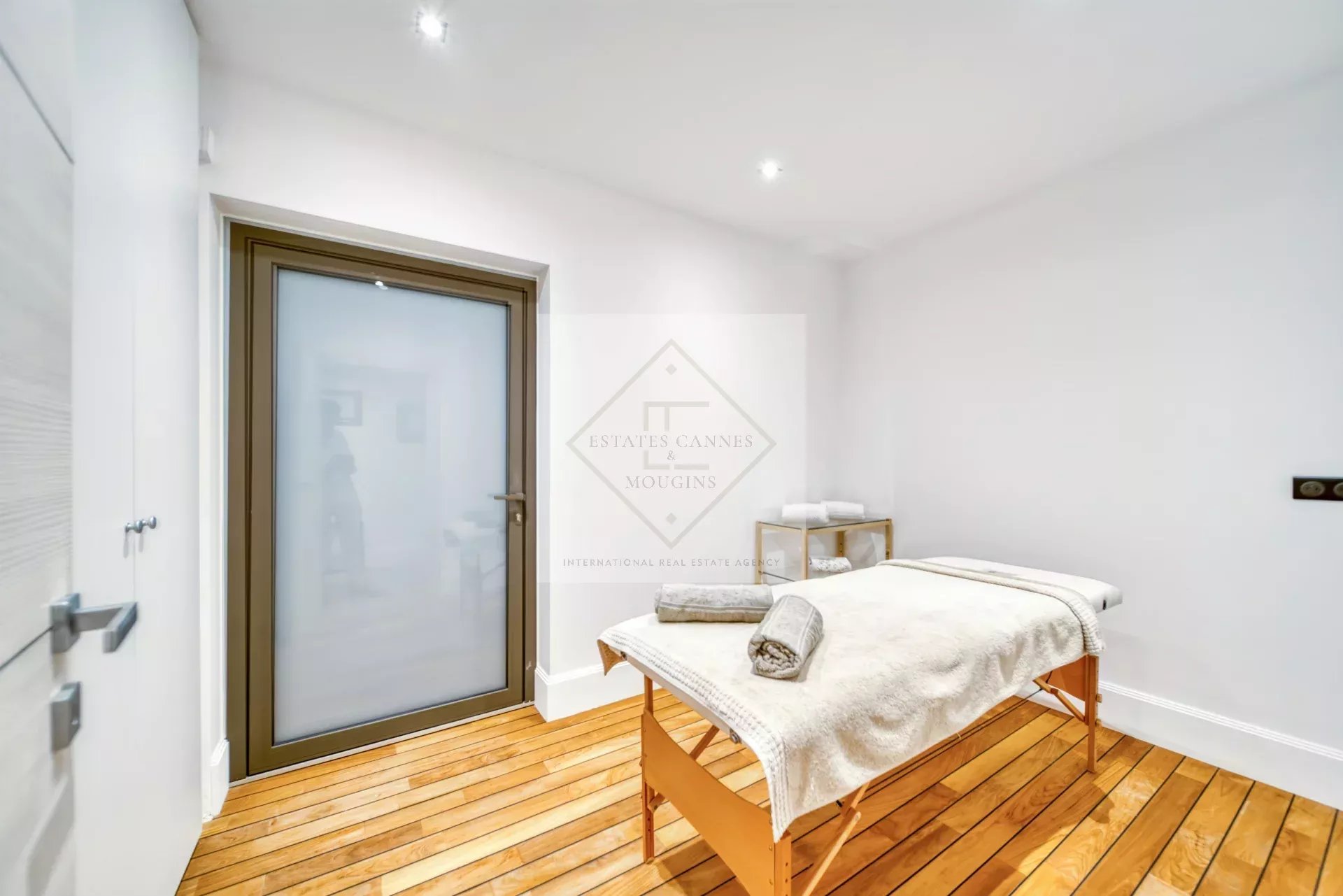 Intérieur d'une villa avec une table de massage et un sol en bois.