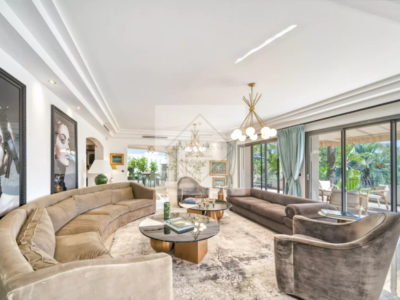 Intérieur d'une villa luxueuse avec salon spacieux et vue sur le jardin.