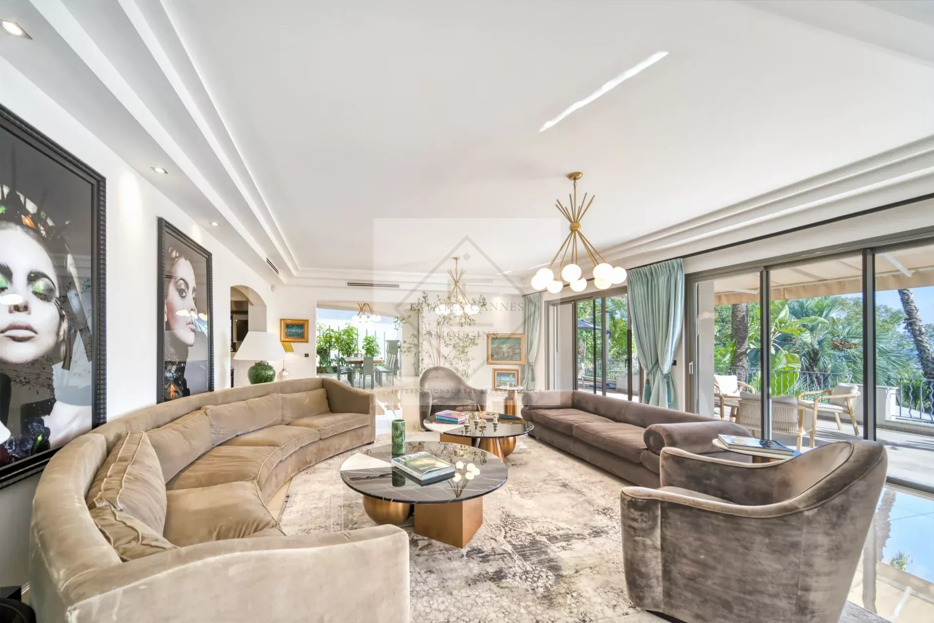 Intérieur d'une villa luxueuse avec salon spacieux et vue sur le jardin.