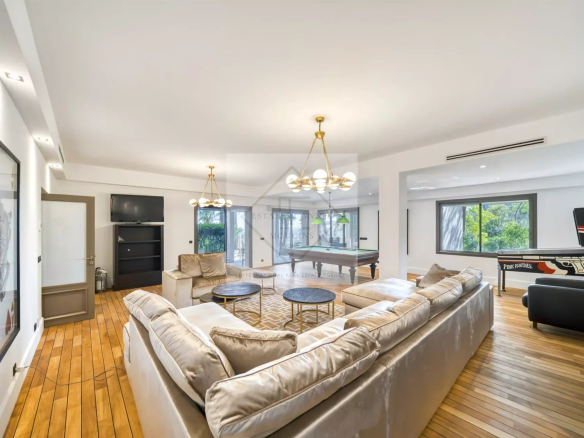 Intérieur d'une villa spacieuse avec un salon lumineux et un sol en bois.