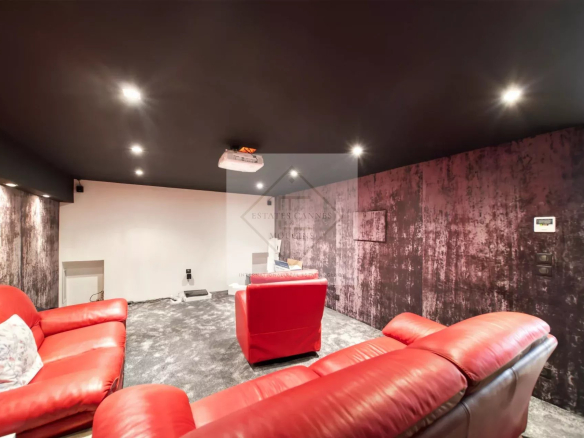 Intérieur d'une villa avec un salon confortable et un projecteur au plafond.